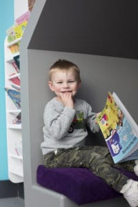 Little boy sitting happily in the story corner