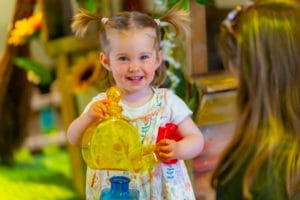 Little girl with bunches playing with potion bottles