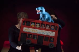 Blue puppet trex on a red London bus
