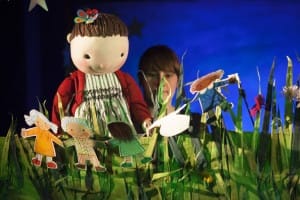 Puppets with their paper dolls in the grass