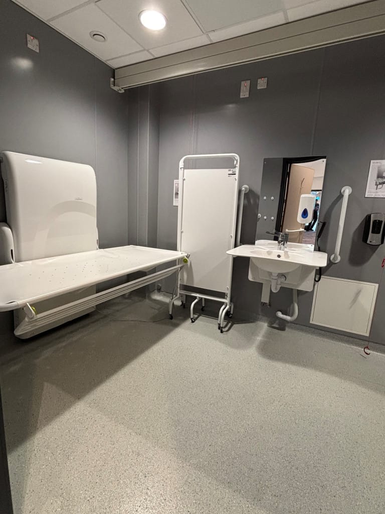 View of the hoist and wash basin in the Changing Places Toilet room. 