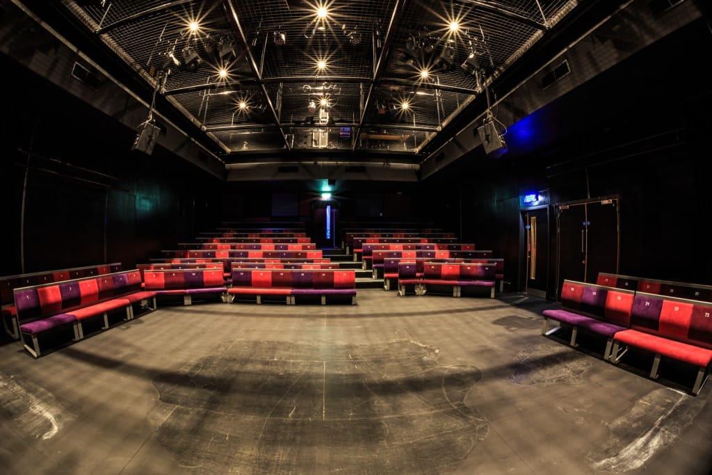 The theatre space with rows of seats and an empty stage.