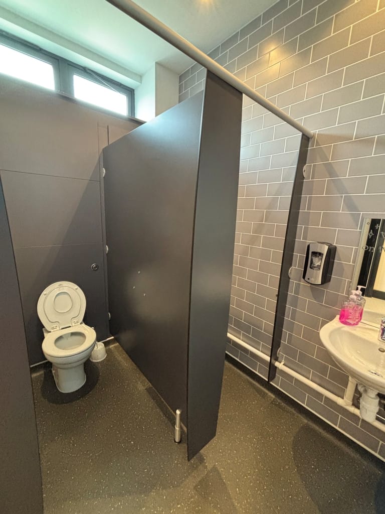 Male toilet room with 2 cubicles and a wash basin