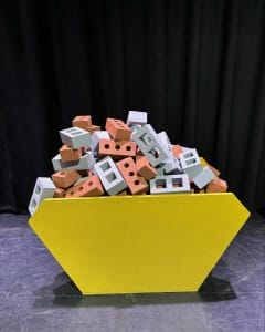 A toy skip full of toy building blocks that look like bricks