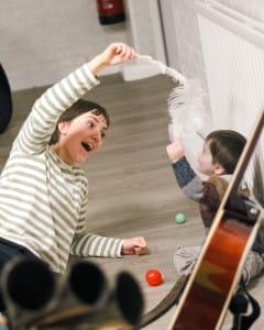 A performer playing with a feather and a child