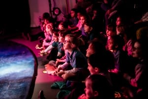 Children sitting on the floor watching The Sleep Show.