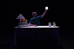 Actor on set up holding up a lit up square prop