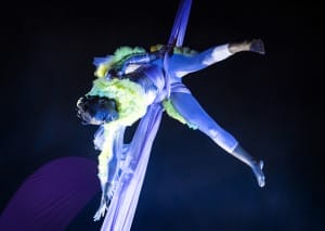 An actress hoisted up in aerial silks